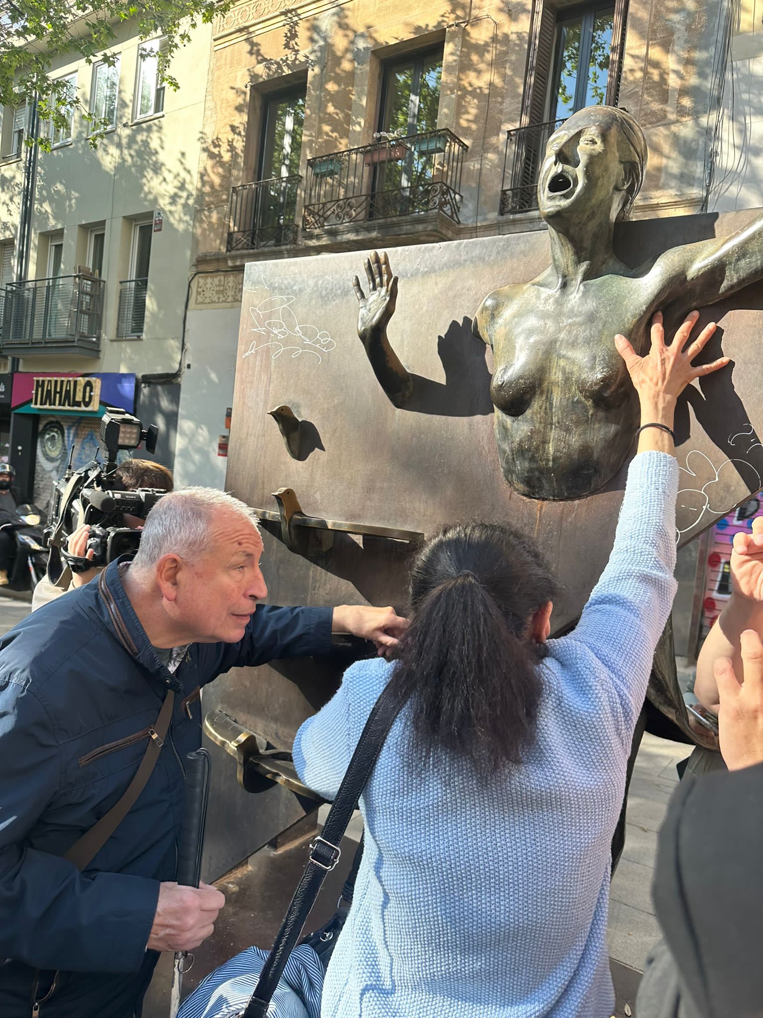Dues persones cegues toquen el monument a 'La Colometa' a La Plaça del Diamant.