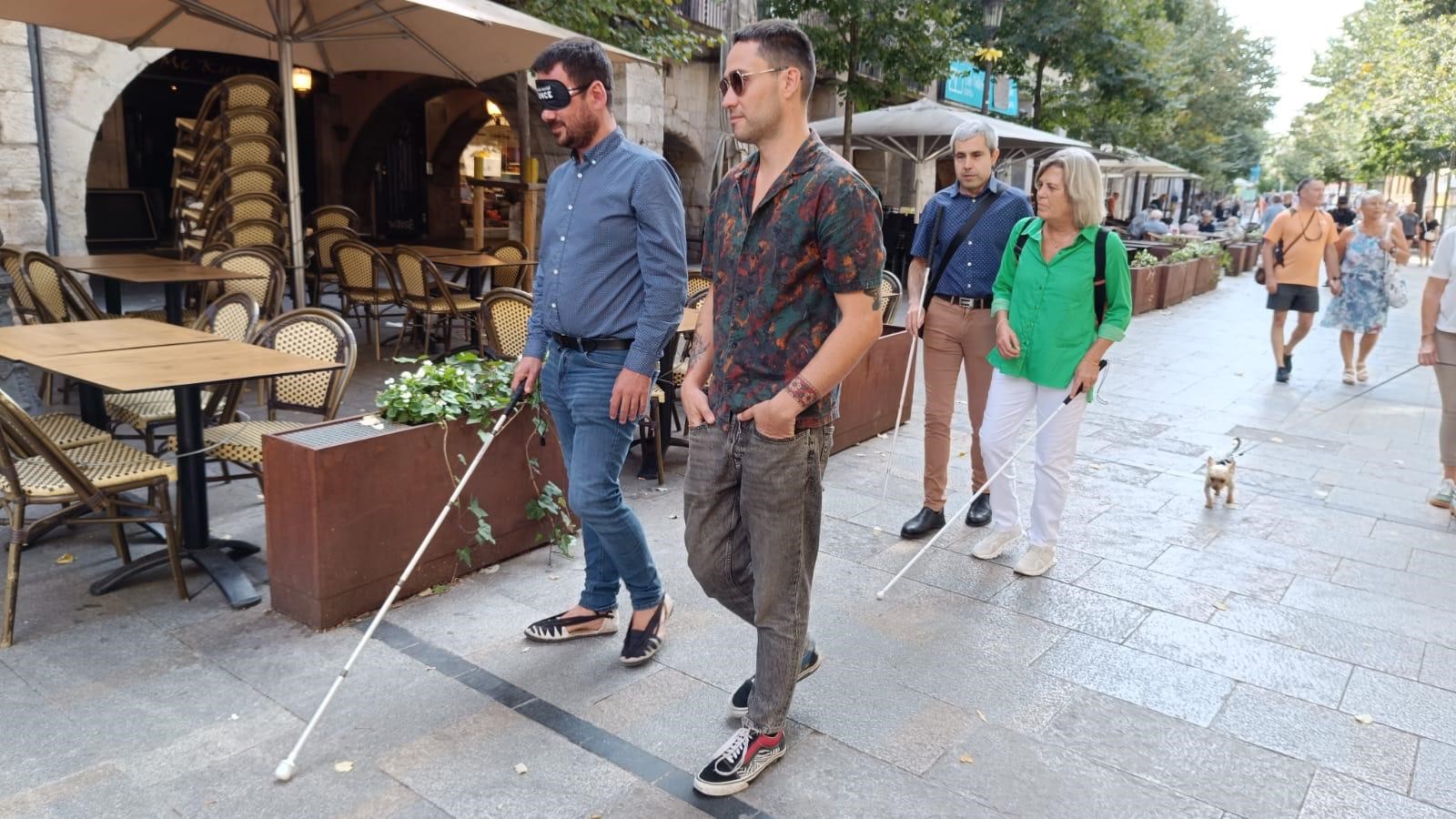 Lluc Salellas, alcalde de Girona, passeja a cegues pels carrers de la ciutat amb antifaç i bastó.