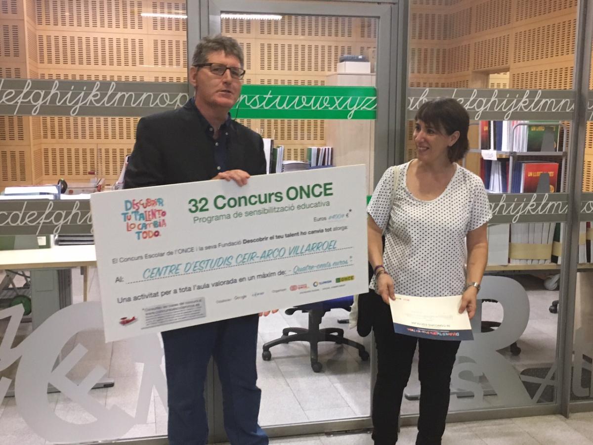 Manel Eiximeno, director del CRE ONCE Barcelona, entrega a la professora del CEIR ARCO-VILLARROEL el xec com a guanyadors de la categoria D del Concurs Escolar de l'ONCE i la seva Fundación.