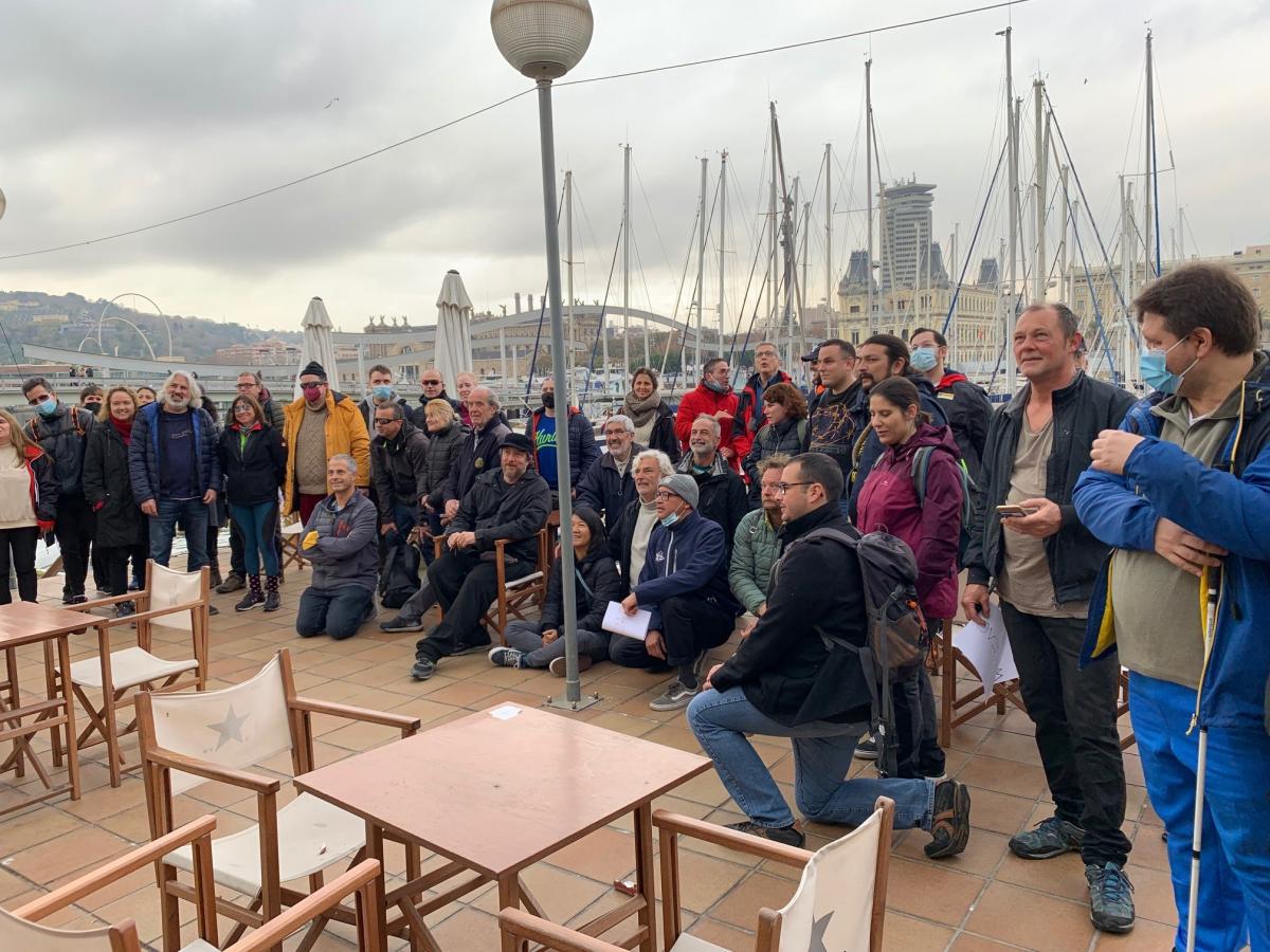 Grup de persones de l'ONCE Catalunya, entre persones cegues i acompanyants, ii patrons del Reial Club Marítim de Barcelona, abans de sortir a navegar.