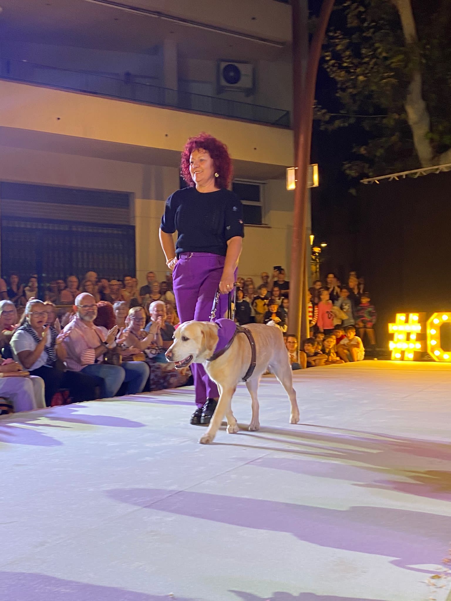 L'afiliada a l'ONCE, Pepi Carreta, usuària de gos pigall, en un moment de la seva desfilada.