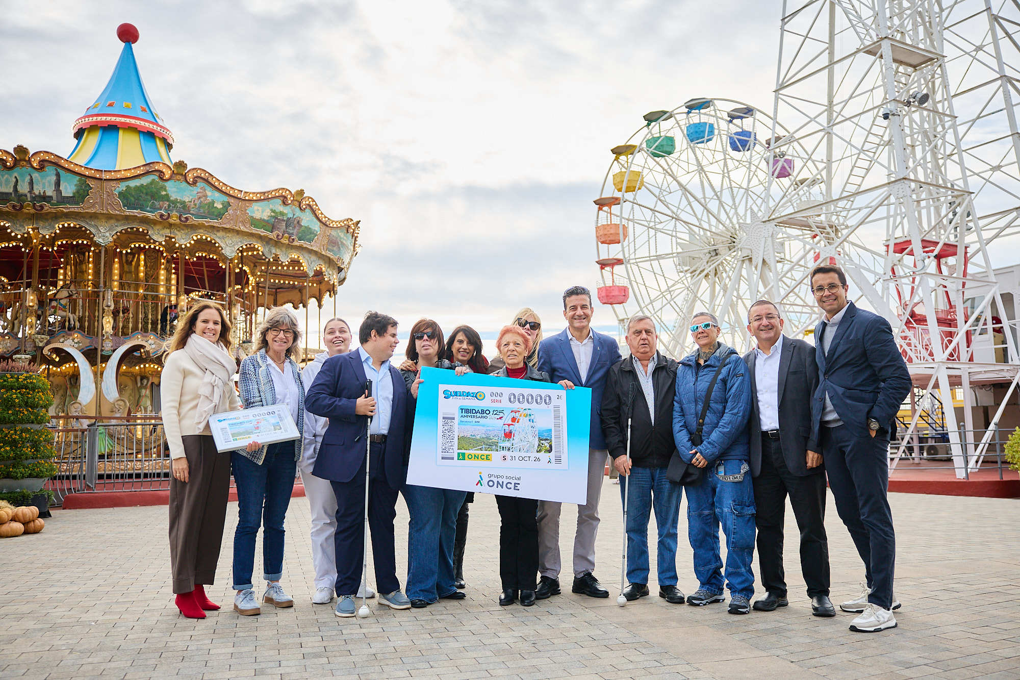 Angel Ávila, sotsdelegat de l'ONCE a Tarragona, i un grup de persones cegues, lliuren el cupó a la direcció del Tibidabo.
