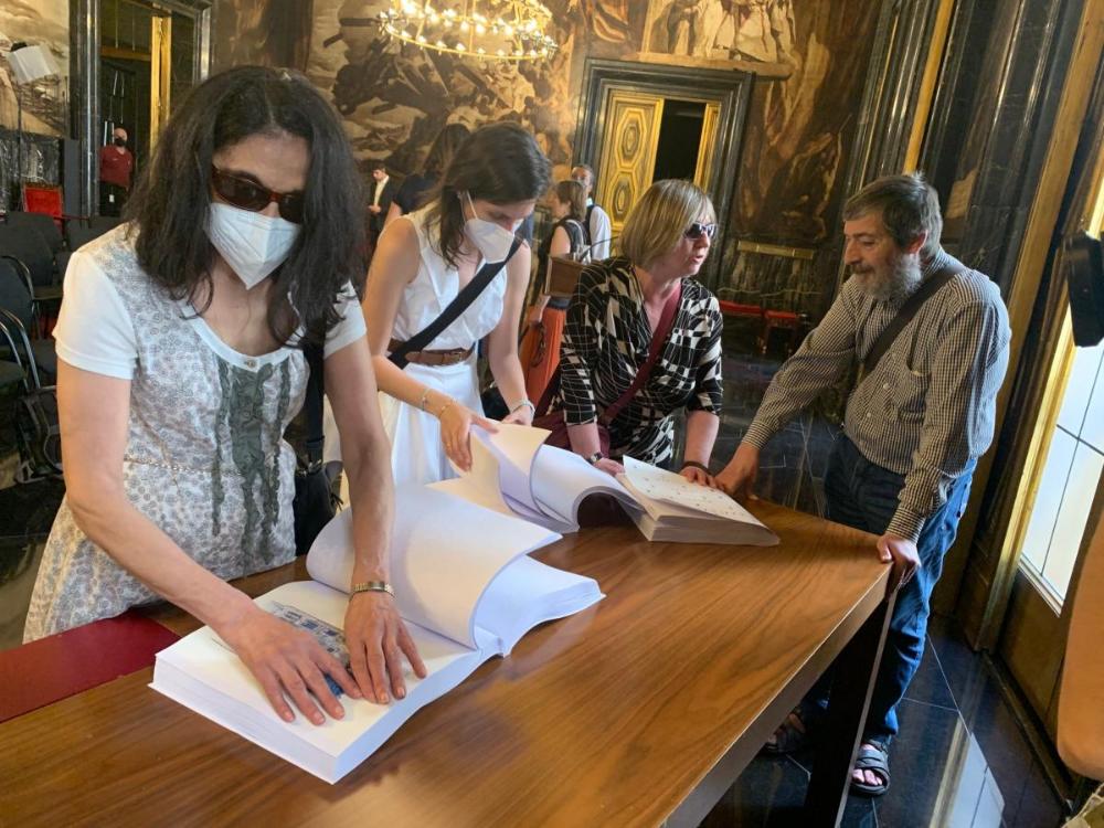 Un grup de persones cegues llegeixen en braille 'Barcelonas' de Vázquez Montalbán.