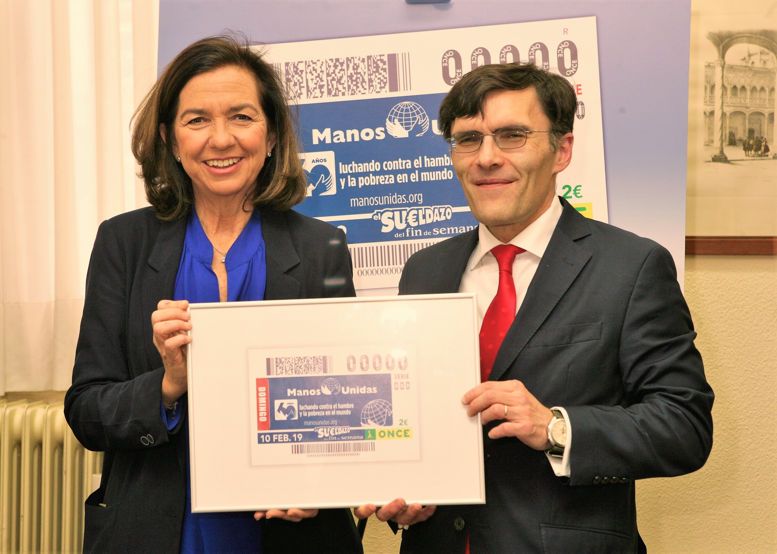 clara_pardo_y_alberto_duran_con_una_imagen_enmarcada_del_cupon_de_la_once_dedicado_al_60_aniversario_de_manos_unidas.jpg
