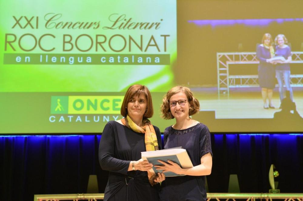 Maria José Sánchez Lorenzo, responsable del Departament de Promoció cultural i Museu Tiflològic de l’ONCE, va lliurar a l’Anna Punsoda, guanyadora del premi de narrativa Roc Boronat de l’any passat un exemplar en Braille i un altre en versió sonora de l’obra Els llits dels altres.