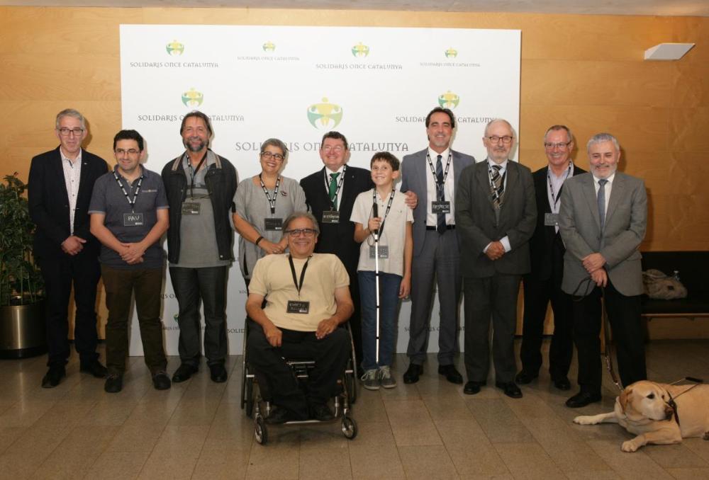 Peu de foto premiats: (d'esquerra a dreta) Ferran Busquets, director de la Fundació Arrels; Marga García, tinenta d'alcalde d'El Prat de Llobregat; Pere Ribes, comentarista del programa  L'Olot a Ràdio; Olot Domènech Roig, president de Tallers Gaudí i  Josep Marí Pàmies (germà de Jaume Marí Pàmies). Amb ells, el director general de l'ONCE, Àngel Sánchez; el Síndic de Greuges, Rafael Ribó i altres autoritats.