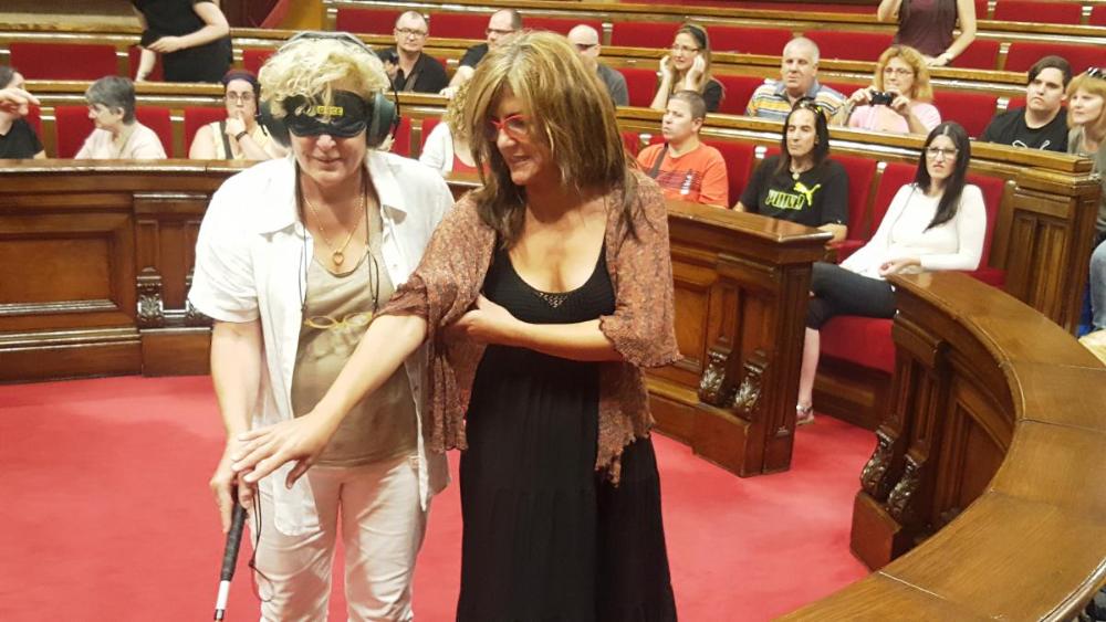 La presidenta de la Comissió d’Afers Socials i Famílies, Magda Casamitjana, va experimentar en carn pròpia què sent una persona que no veu ni pot escoltar. Va fer una volta amb els ulls tapats i uns auriculars.I amb la llengua de signes va dedicar un Bon Dia! als visitants i els va dir que els estimava molt. 