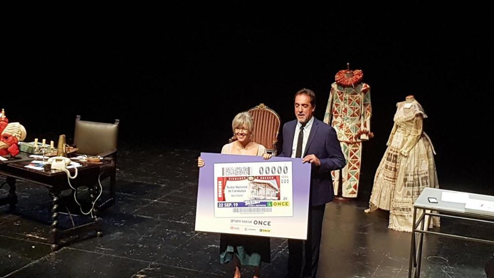 A la presentació van participar Enric Botí, delegat territorial d’ONCE a Catalunya i Mònica Campos, directora executiva del TNC. A la imatge, a l'escenari amb el cupó.