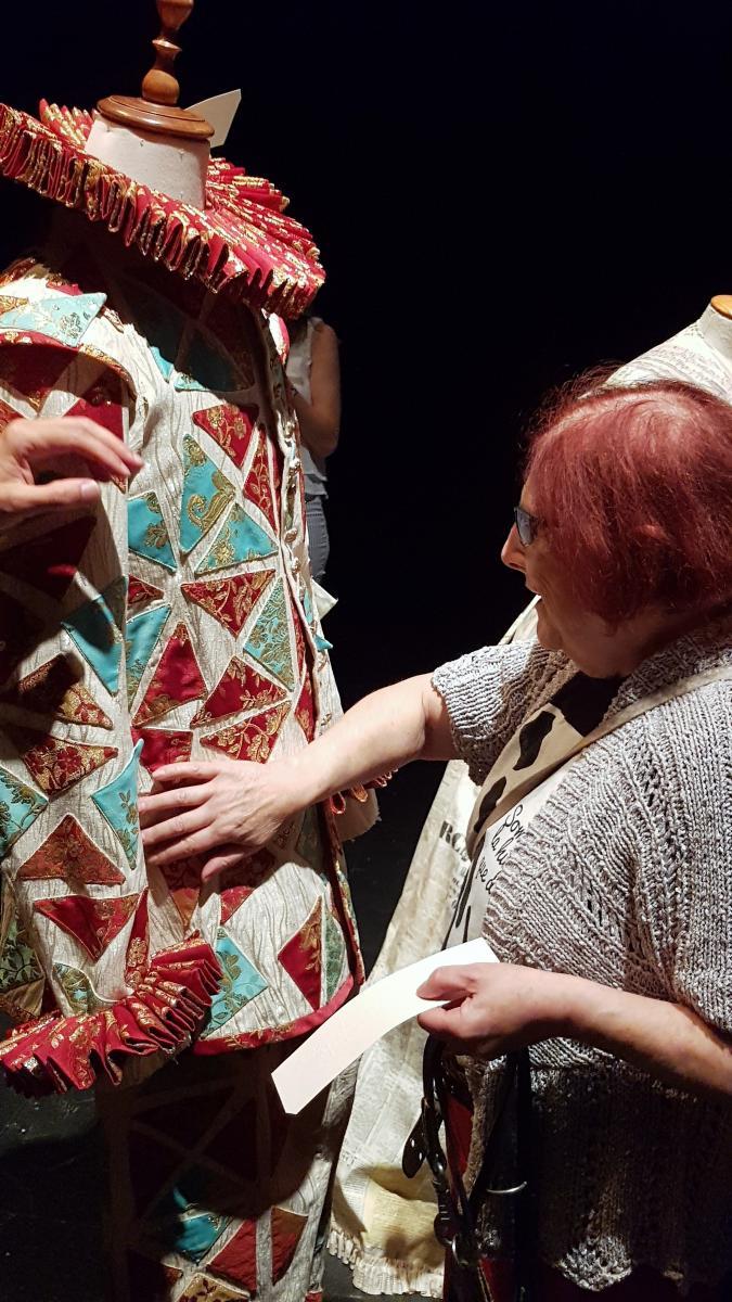 Núria, una actriu afiliada a l'ONCE, toca el vestit de dona d'un maniquí.