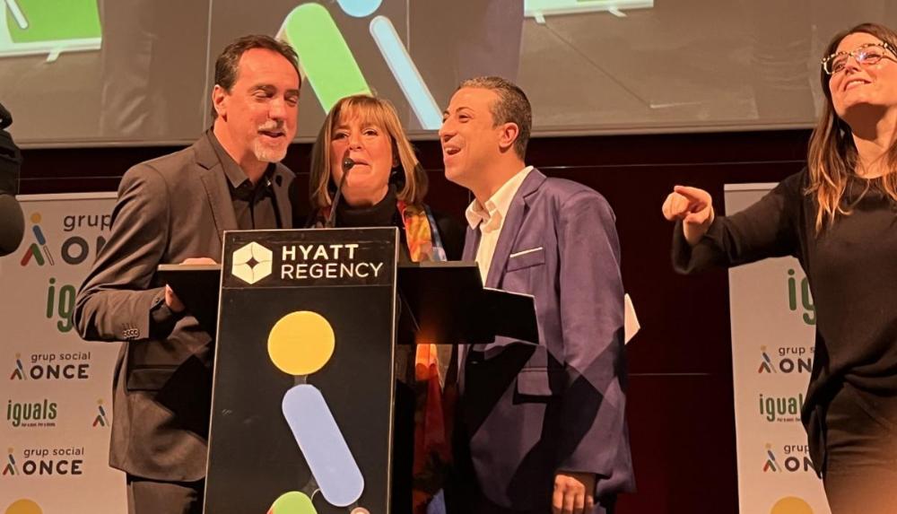 Enric Botí, d'ONCE Catalunya, Núria Marín, alcaldessa de l’Hospitalet de Llobregat i presidenta de la Diputació de Barcelona; David Bernardo, president del Consell Territorial d’ONCE Catalunya, destigen 'Bon Profit' als comensals. A la dreta, intèrpret de signes.