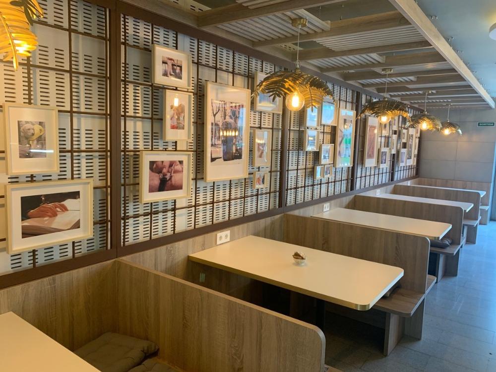 Imatge del renovat Café Il·lusió, a les taules tipus trenet a prop de la terrassa.