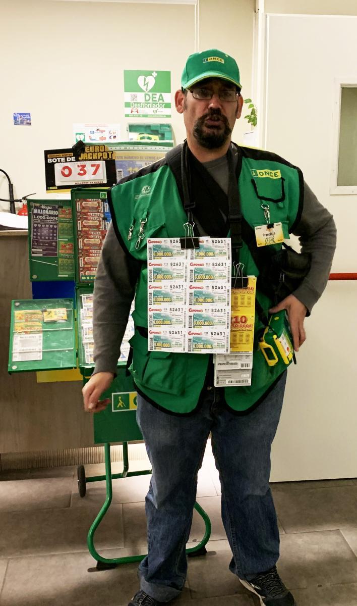 Venedor de l'ONCE, perfectament uniformat, mostra el nou Cuponazo