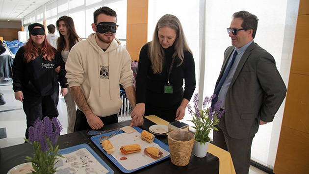  en l’activitat també hi van assistir Marcelino Cid, director de l’ONCE a Lleida i Afra Pascual Almenara, professora associada al Grau en Disseny Digital i Tecnologies Creatives de la Universitat de Lleida., a la foto, amb dos alumnes amb antifaç.per fer un esmorzar a cegues.