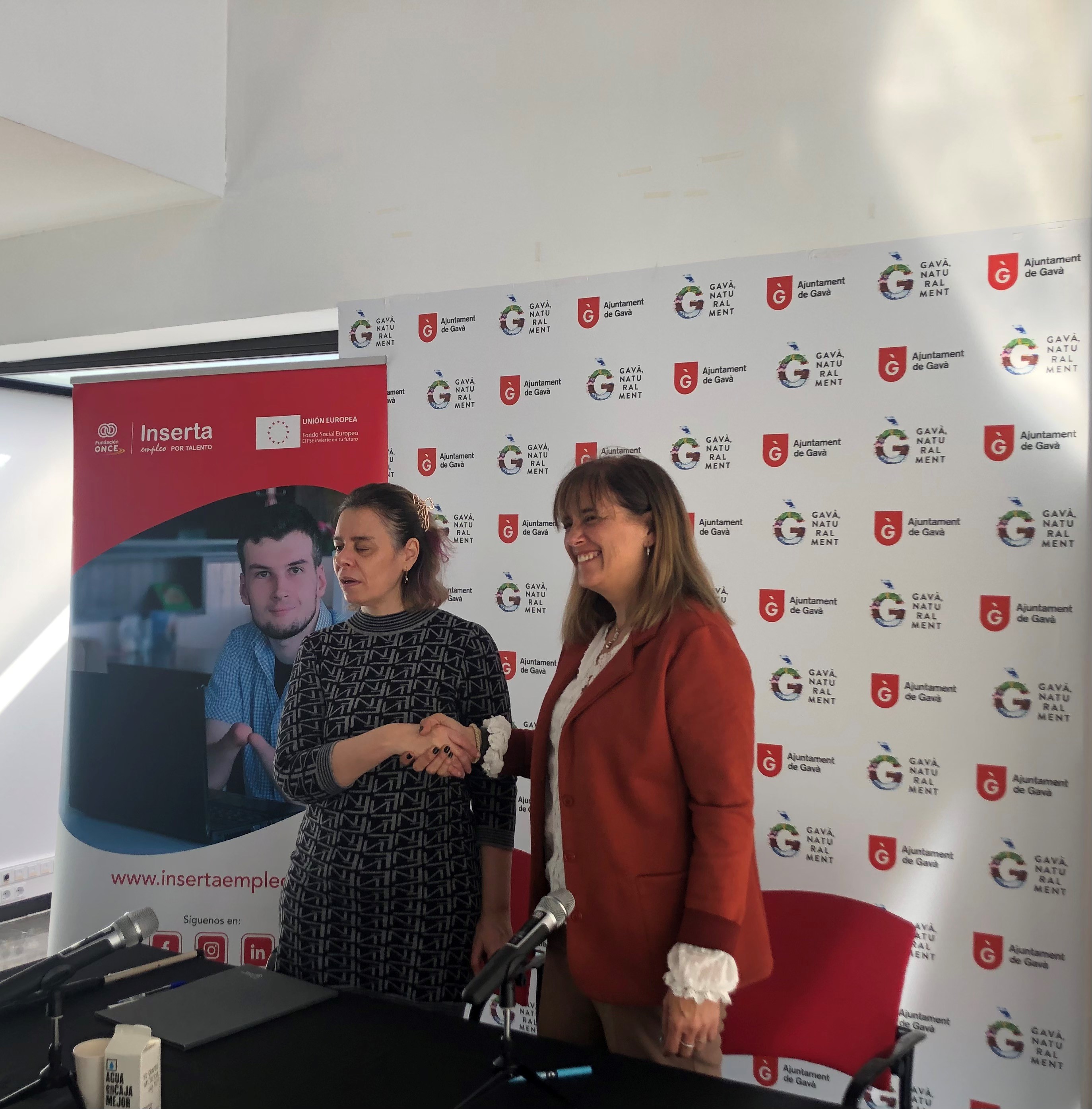 L'alcaldessa de Gavà, Gemma Badia, i la secretària general i directora de Transformació i Excel·lència i Igualtat de la Fundació ONCE i secretària general d'Inserta Empleo, Virginia Carcedo,, donant-se la mà en senyal d'acord