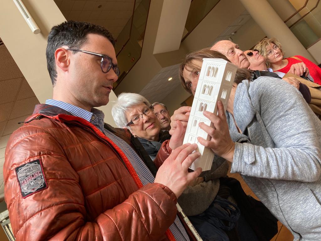 Un des assistents a la visita guiada pel Museu Episcopal tocant una maqueta en 3D