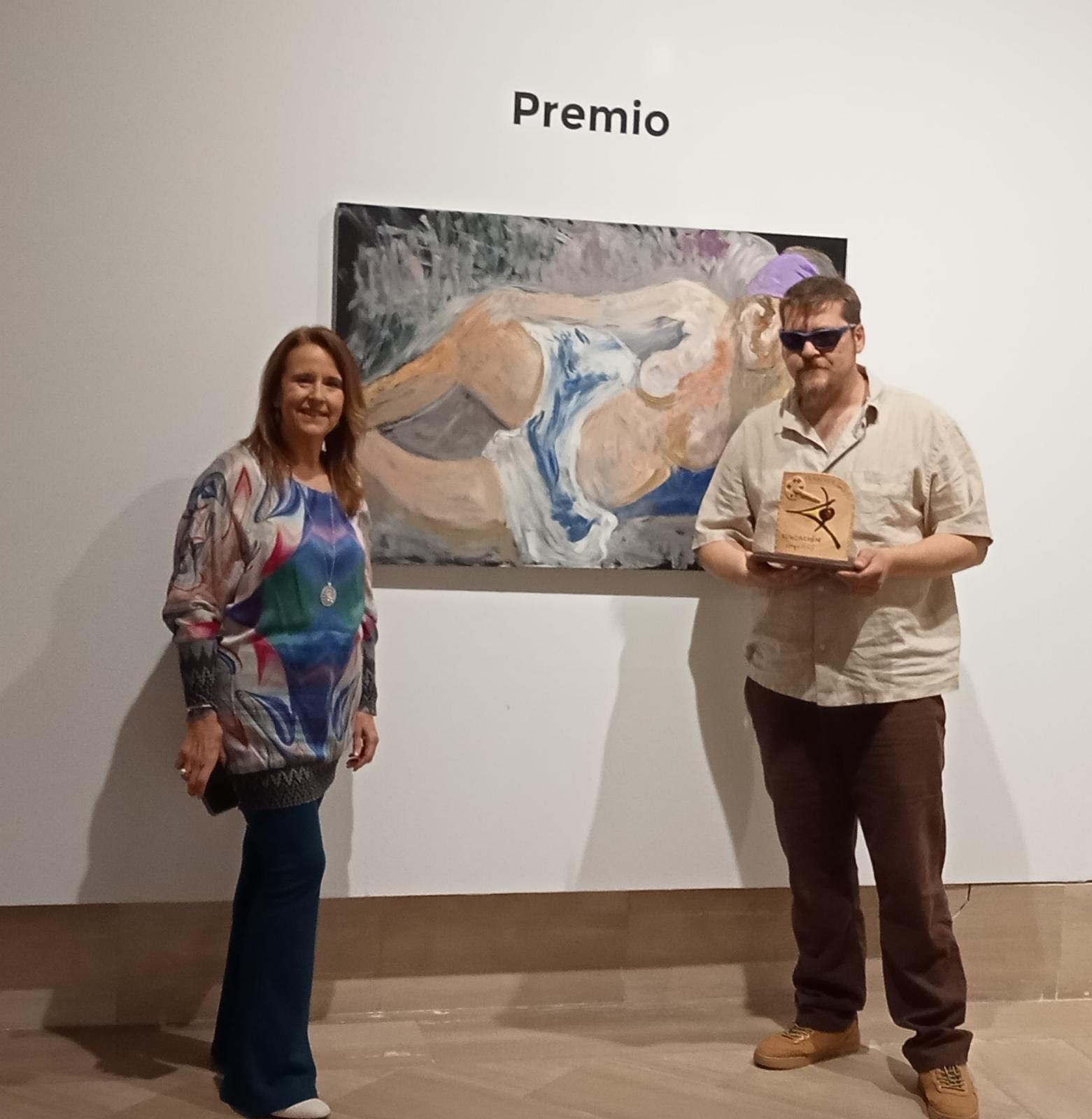 Natan Tarragó, artista i afiliat a l'ONCE, davant de la seva obra amb el premi a la mà