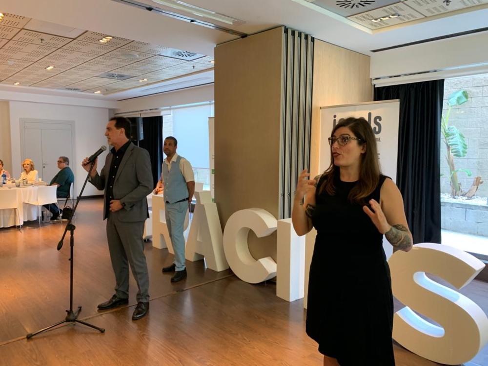 Enric Botí, delegat de l'ONCE a Catalunya,  dirigint unes paraules a tots els assistents. Es veu també a David Bernardo, president del Consell Territorial de l'ONCE a Catalunya, i a la interpret de signes. 