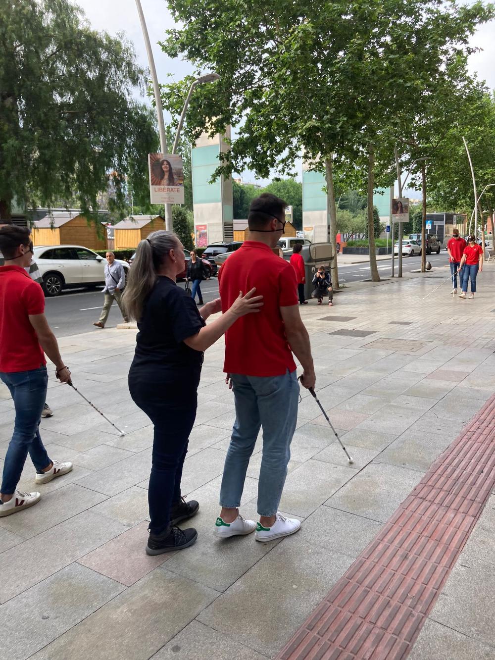 Persones amb bastó blanc caminant pels carrers de Reus ajudats per tècnics de rehabilitació de l'ONCE