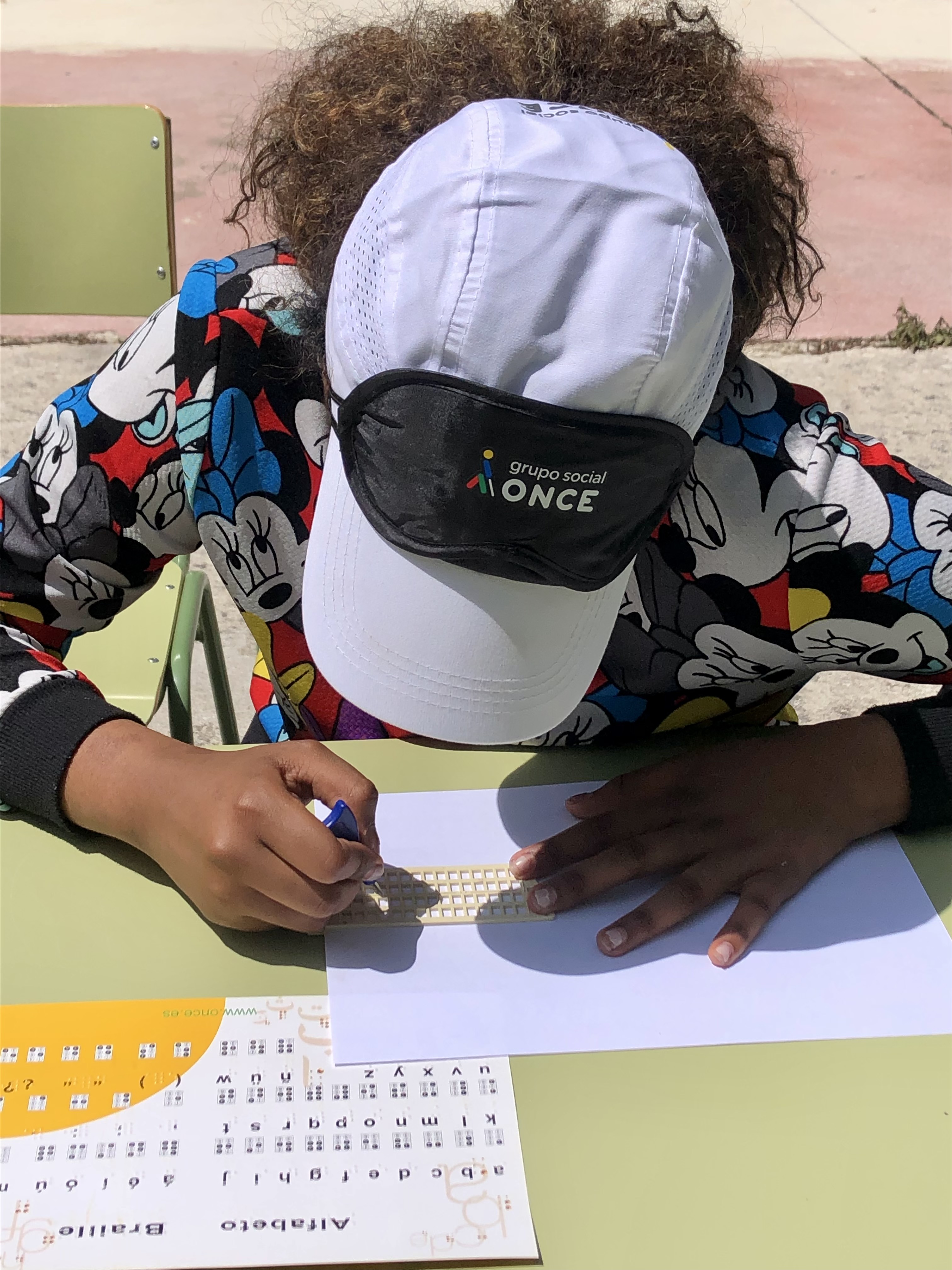 Una estudiant escriu en braille amb un punxó.