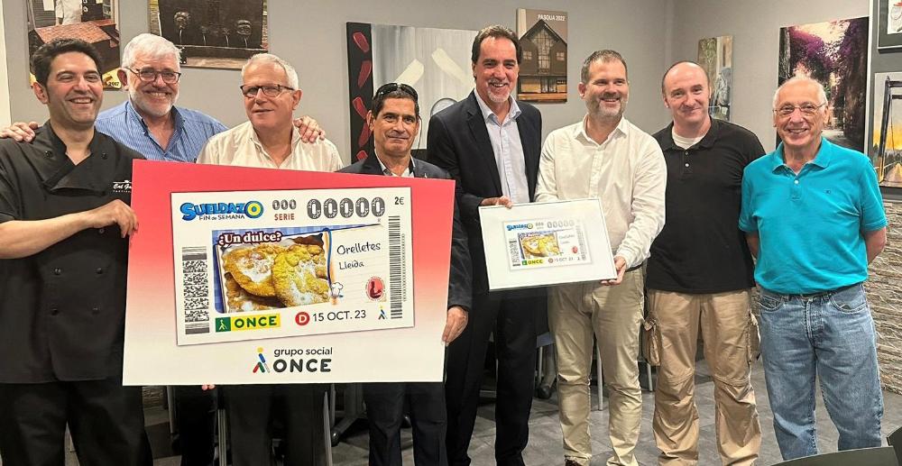Enric Botí, delegat de l’ONCE a Catalunya, va lliurar a Ricard Pérez, alcalde d’Oliana, i al pastisser Eduard Romero, una imatge emmarcada del cupó dedicat a les Orelletes. Van participar a l’acte, el 10 d’octubre, Antonio Romero, conseller territorial de Lleida;  Josep Masana, president del Comitè d’Empresa de Lleida; i un grup de persones cegues, que van poder degustar aquestes postres, després de participar en el procés final, tot tocant i estirant les Orelletes