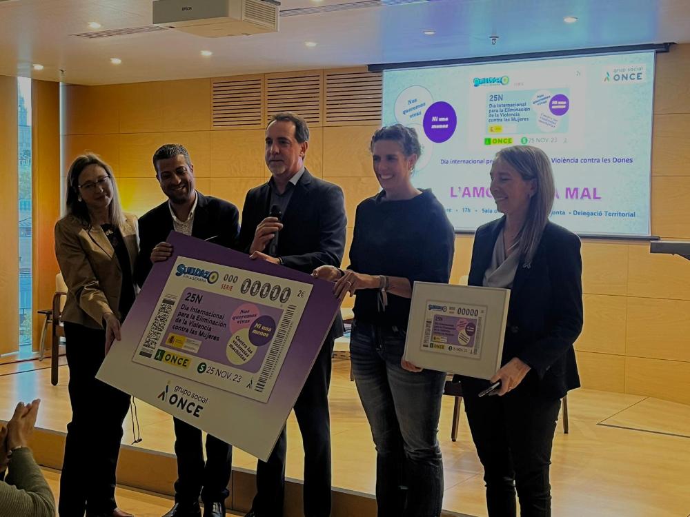 Enric Botí, delegat de l’ONCE a Catalunya i David Bernardo, president del Consell Territorial de l’ONCE a Catalunya, van fer a mans d'Èlia Soriano, directora de l’Institut Català de les Dones, una imatge del cupó de l'ONCE de dissabte, 25 de novembre, dedicat al Dia Internacional de l'Eliminació de la Violència contra la Dona. També a la foto María Sierra López i Dolors Guiu.