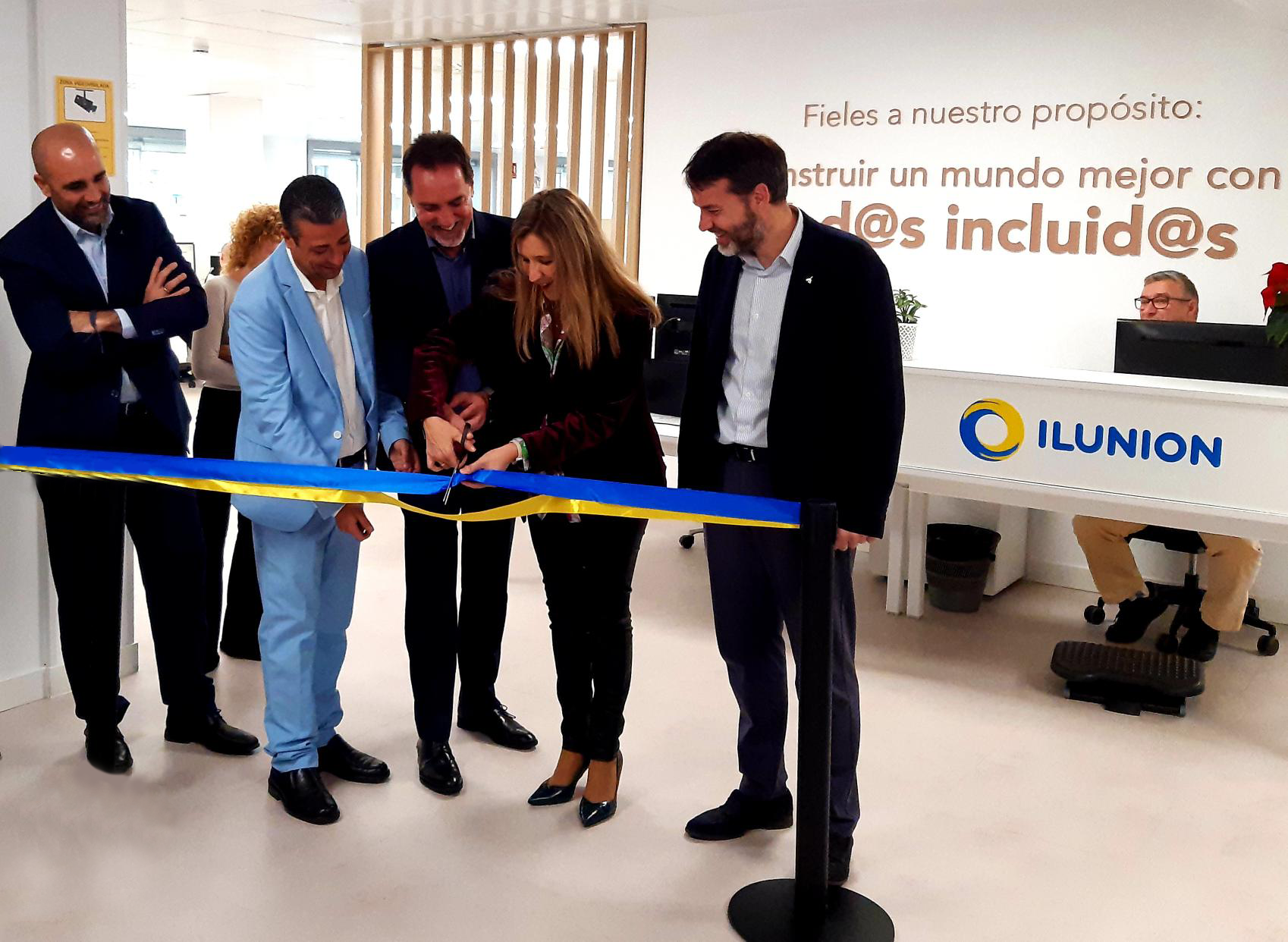 Imatge on es veuen als responsables assistents tallant una cinta blava i groga per representar la inauguració del centre