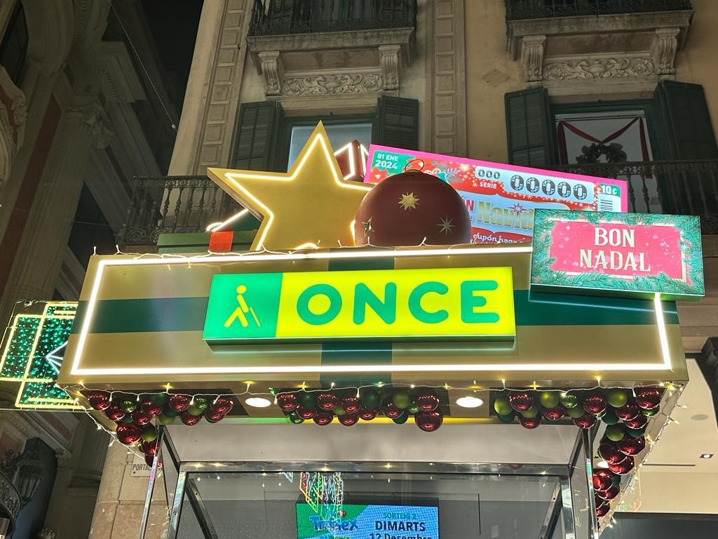 Un cupó gegant del Sorteig Extraordinari de Nadal de l'ONCE, amb boles de l'arbre de Nadal, estrelles i paquets de regal, es van pujar a la teulada dels quioscos de l'ONCE.
