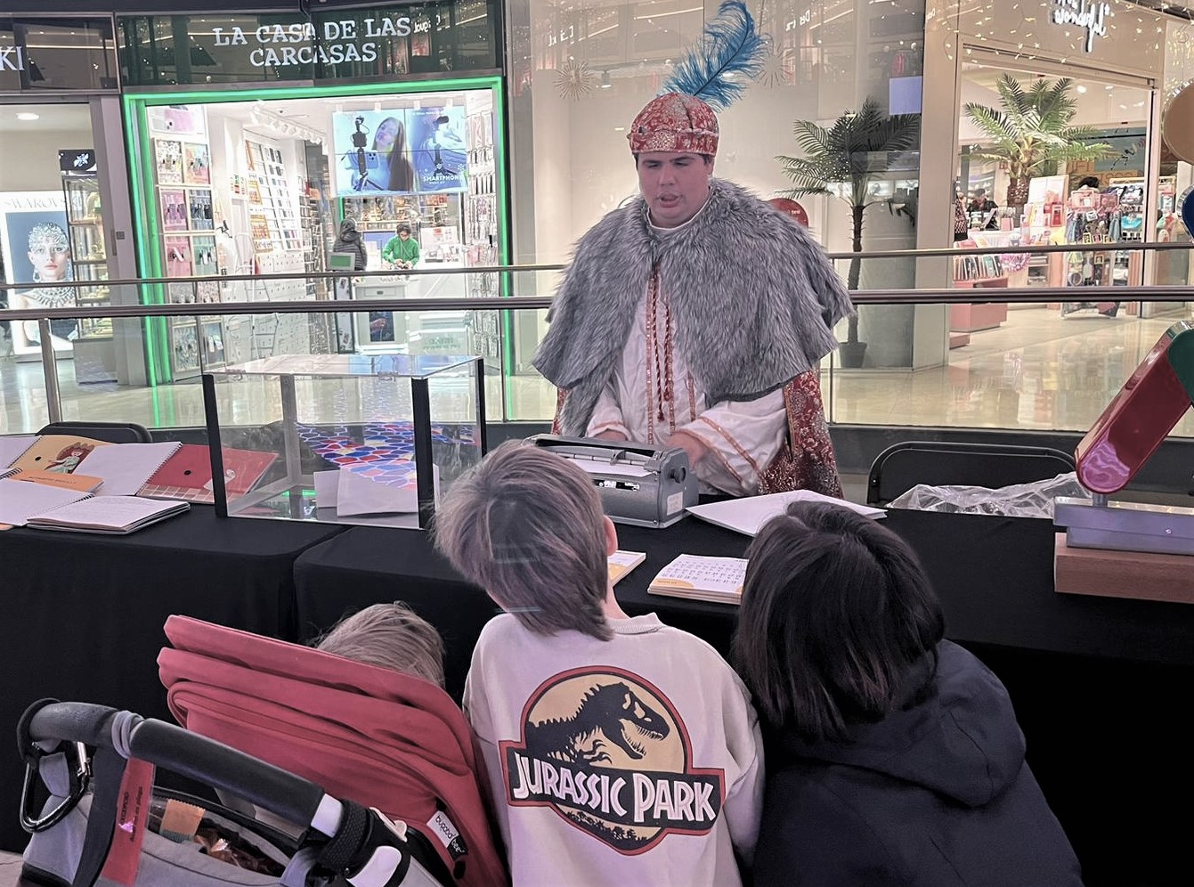 El Patge Reial que escriu i llegeix amb braille amb tres nens al CC Arenas de Barcelona.