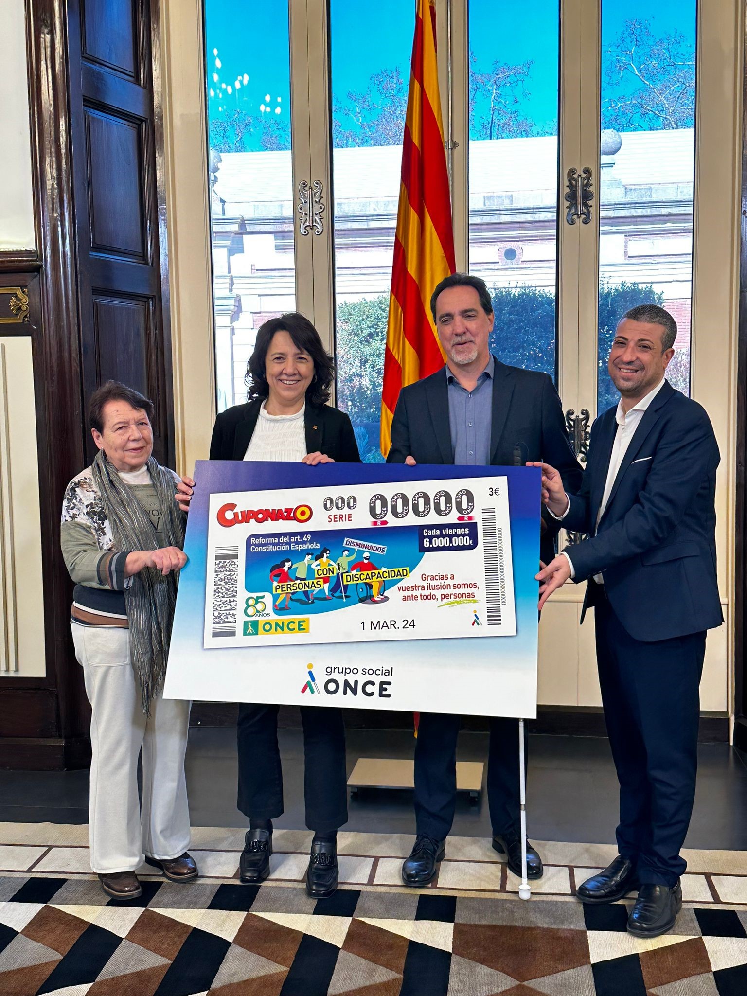 Enric Botí, delegat de l’ONCE a Catalunya i David Bernardo, president del Consell Territorial de l’ONCE a Catalunya, acompanyats per Mercè Batlle, presidenta del COCARMI, van lliurar a Anna Erra, presidenta del Parlament de Catalunya, una imatge emmarcada del ‘Cuponazo’ de l'1 de març dedicat a la reforma de l'article 49 de la Constitució que ha permès eliminar el terme “disminuït” i canviar-lo per “persones amb discapacitat”. 