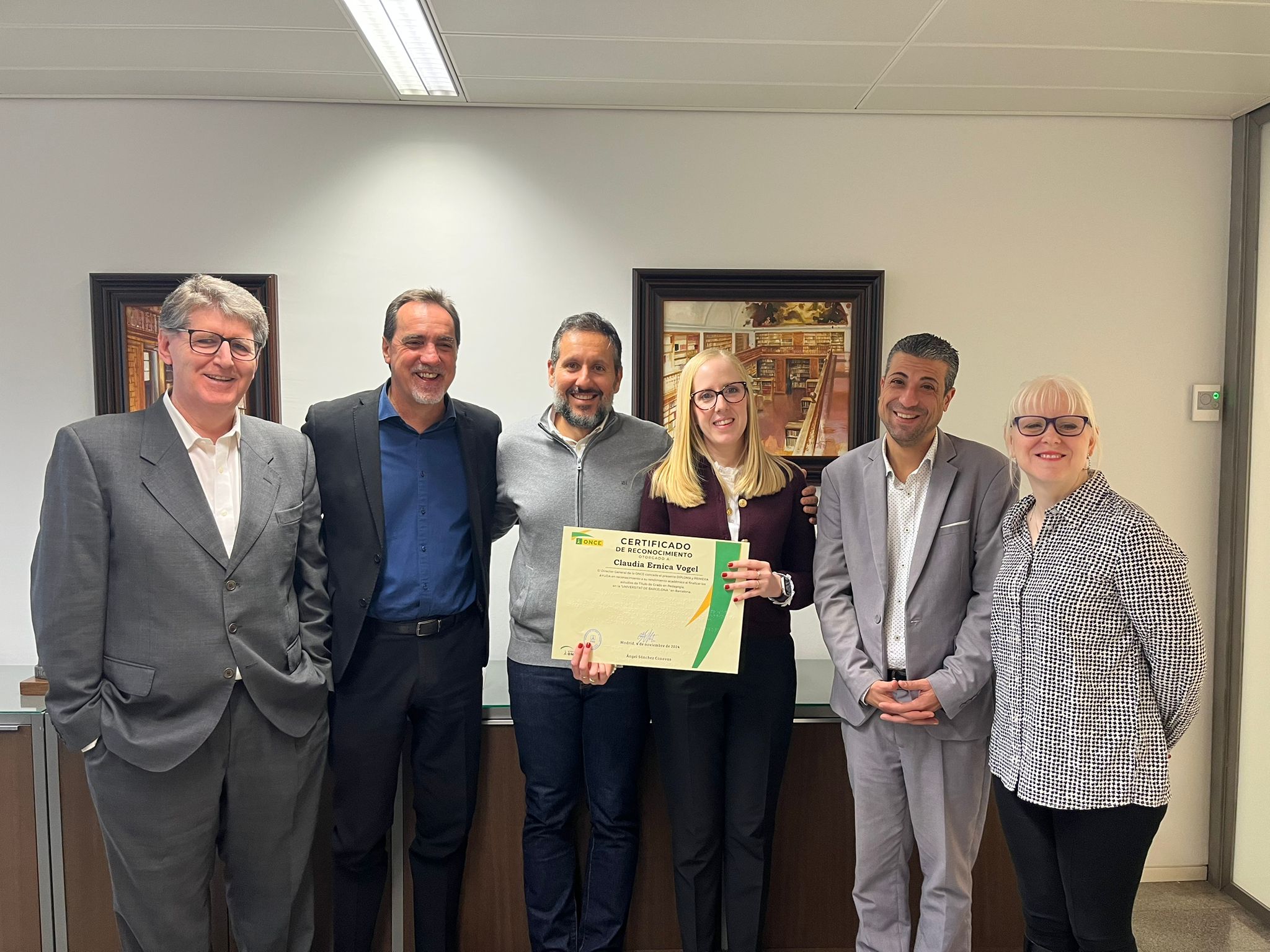 Enric Botí, delegat de l’ONCE a Catalunya; David Bernardo, president del Consell Territorial de l’ONCE a Catalunya; Dolors Luna, cap del departament de Serveis Socials per a persones afiliades; i Manel Eiximeno, director del CRE ONCE Barcelona van lliurar el diploma a a Claudia Ernica Vogel, certificat en reconeixement al seu rendiment acadèmic en finalitzar els estudis de Títol de Grau en Pedagogia a la Universitat de Barcelona (acompanyada per la seva parella, a la foto).