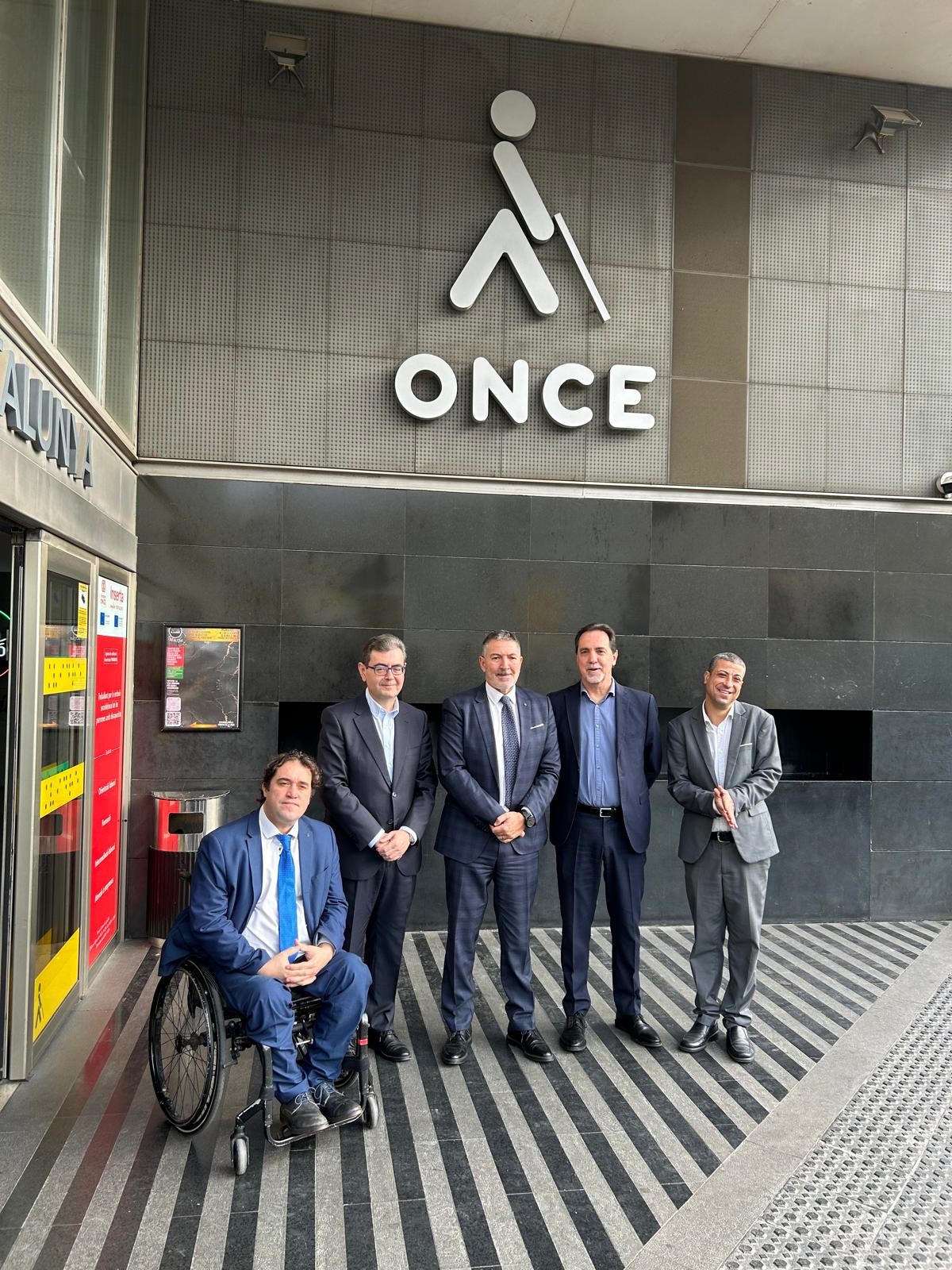 A les portes de l'Edifici Catalunya: L'Hble. conseller d’Empresa i Treball de la Generalitat de Catalunya, Miquel Sàmper;	David Bonvehí, director general de Economía Social i Solidària i Cooperativisme; Enric Botí, delegat de l’ONCE Catalunya; Francisco Botía, director de desenvolupament de programes i recursos públics de Fundació ONCE i David Bernardo, president del Consell Territorial de l’ONCE a Catalunya.