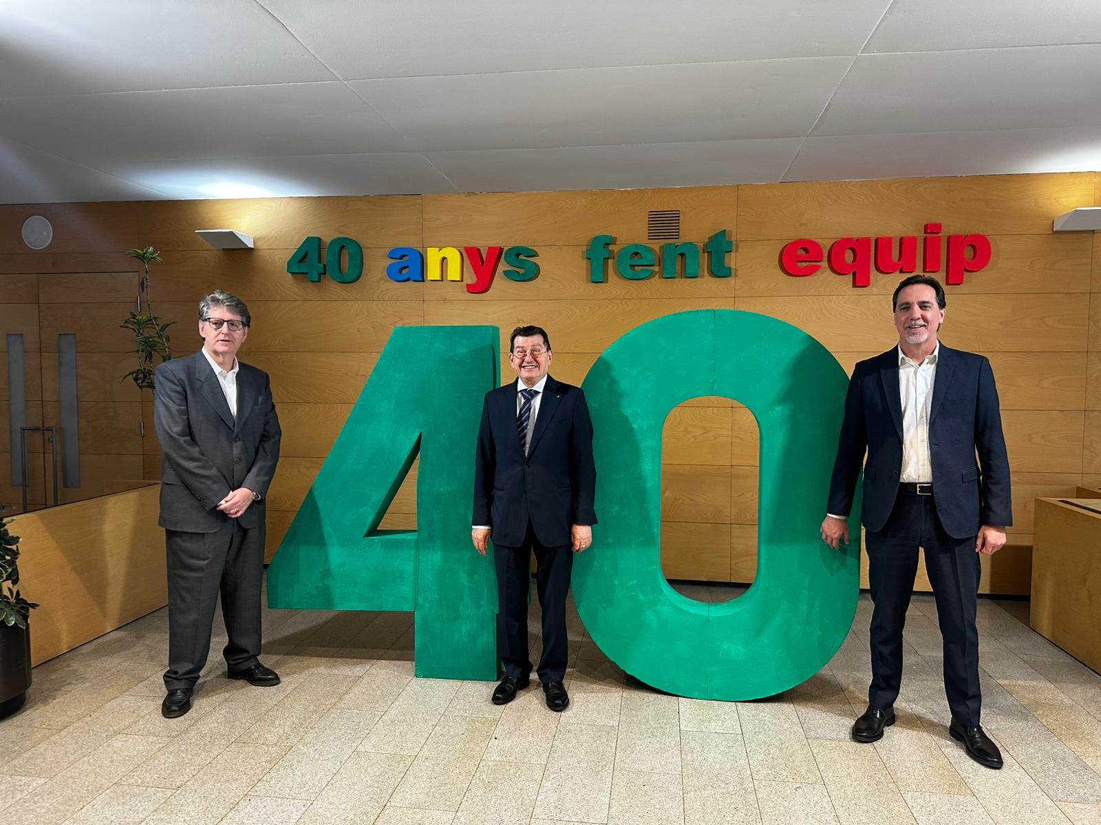 Manel Eiximeno, director del CRE ONCE Barcelona; Ángel Sánchez, director general de l'ONCE; i Enric Botí, delegat de l'ONCE a Catalunya, amb un muntatge on es veu un gran número 40 de color verd i unes lletres enganxades a la paret on posa 