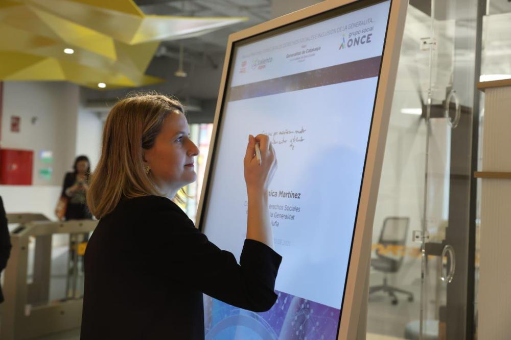 La Consellera escrivint en una pissarra digital del hub