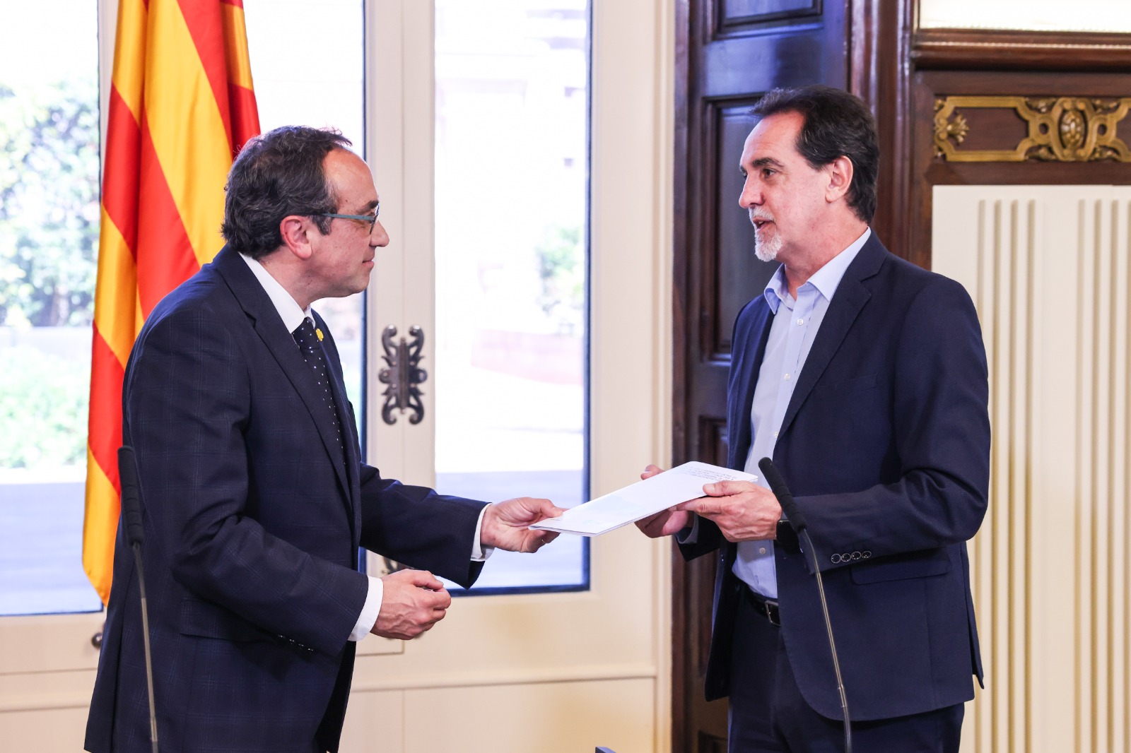 El president del Parlament, Josep Rull, amb Enric Botó, delegat de l'ONCE a Catalunya, amb una còpia en braille del conveni.