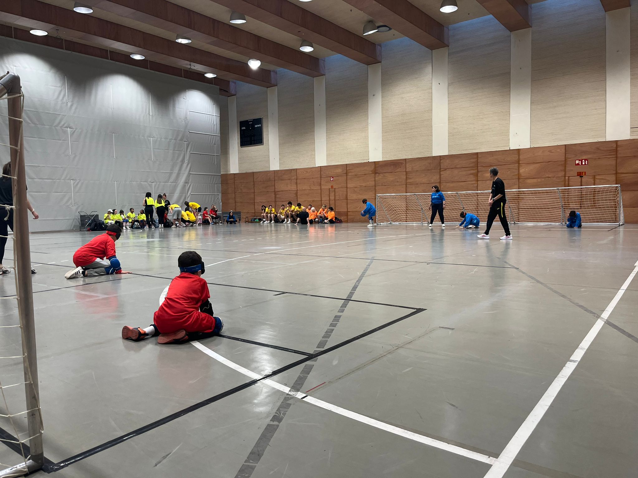 Nens i nenes jugant a goalball al Poliesportiu ONCE Catalunnya.