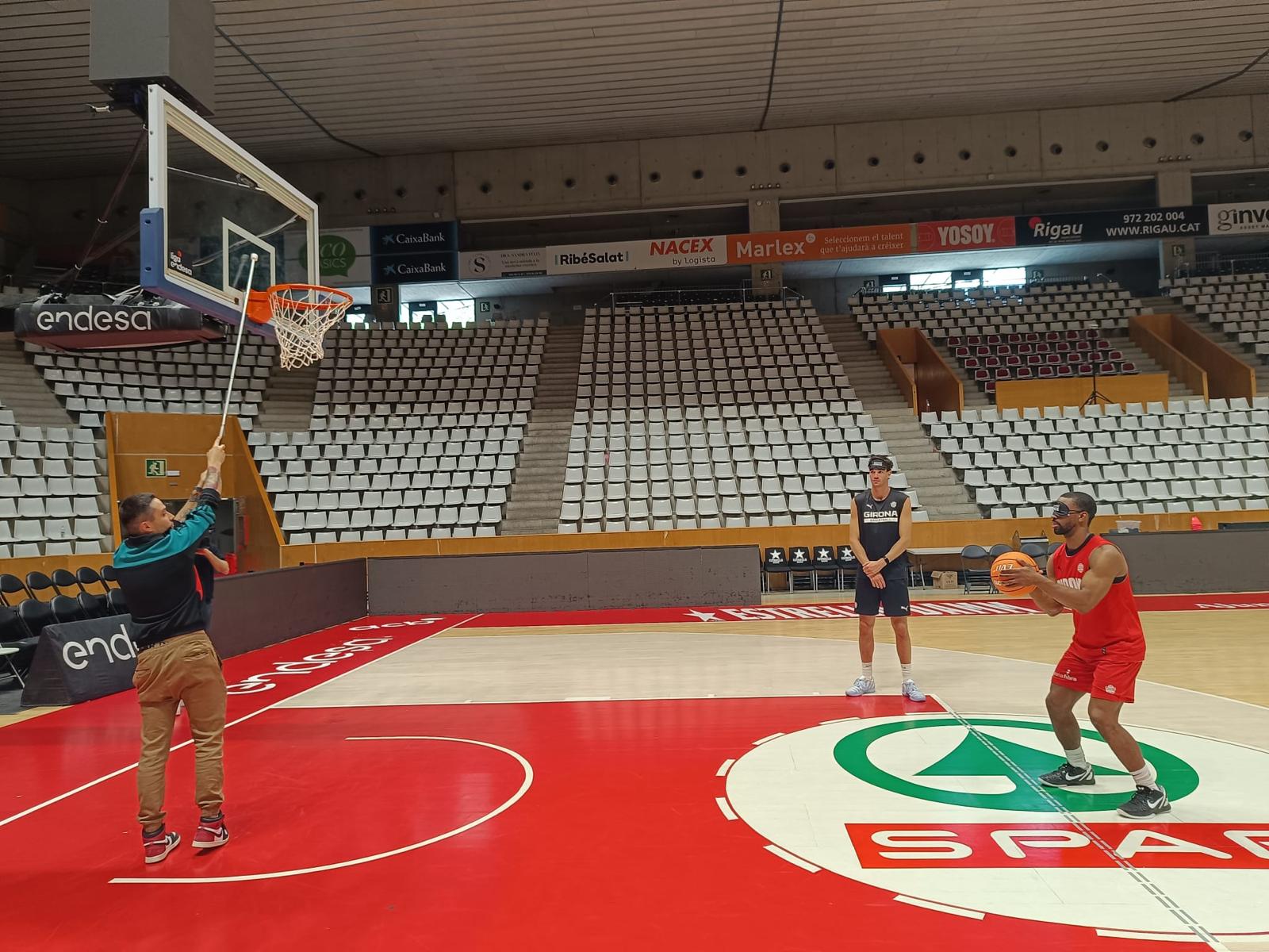 Pep Busquets i Derek Needham, jugadors del Bàsquet Girona, encistellen a cegues.