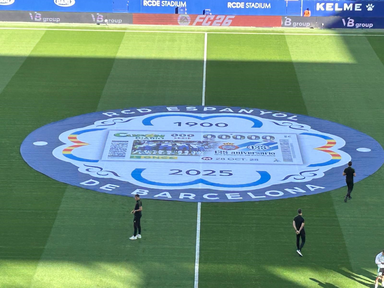 Al centre del camp, va lluir una lona amb l’escut commemoratiu del 125è aniversari 1900-2025 i al centre la imatge del cupó perico.